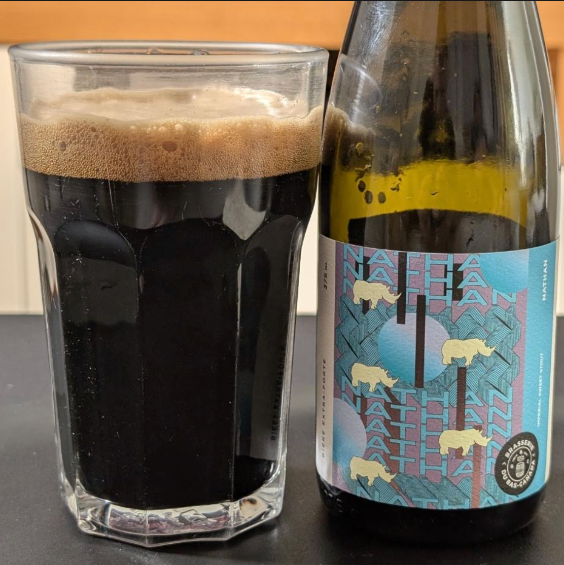 Brasserie du Bas-Canada – Nathan

ABV: 10,5 % | Stil: Imperial Milk Stout | Untappd: 4,54

Nathan er en af Brasserie du Bas-Canadas mest ikoniske dessertstouts. Denne Imperial Milk Stout er brygget med mandler, kokos samt vanilje fra Madagascar og Uganda, hvilket skaber en overdådig og silkeblød stout med masser af dybde, ristede malte og en luksuriøs dessertkarakter.