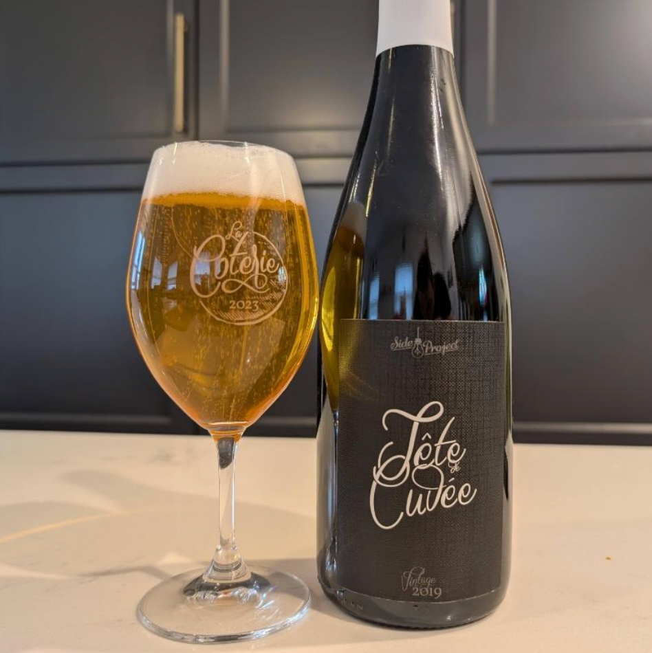 Side Project Brewing – Tête de Cuvée (Vintage 2019)
ABV: 7,0 % | Stil: Farmhouse Ale / Saison | Untappd: 4,44

Tête de Cuvée (Vintage 2019) er en raffineret, fadlagret saison skabt som en speciel vintage‑blend af nogle af Side Project’s bedste sæsoner, der har modnet i egetræsfade for at udvikle kompleksitet og balance.